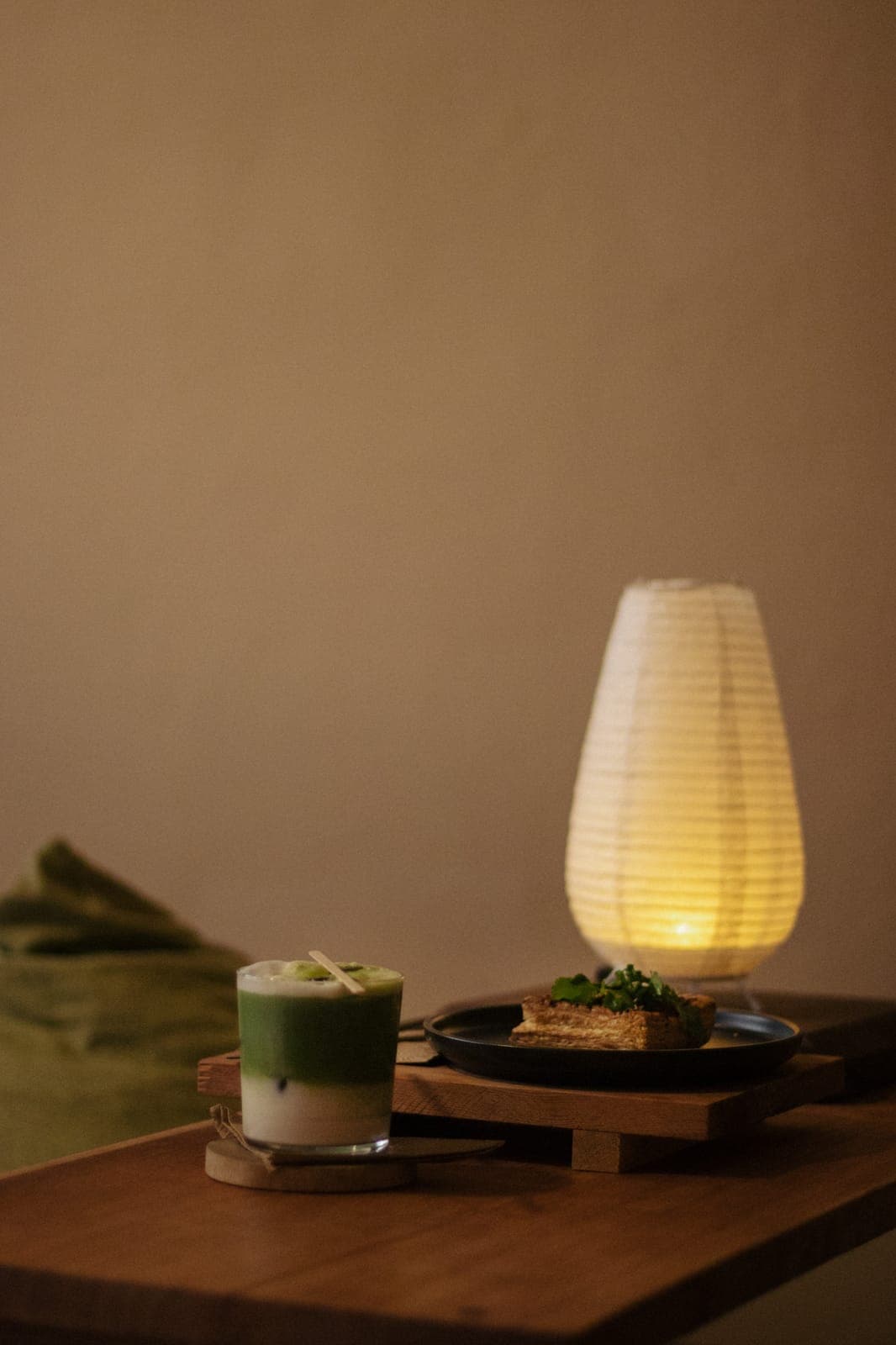 Mesa con matcha, comida y lámpara de papel en Deseo Nada Más